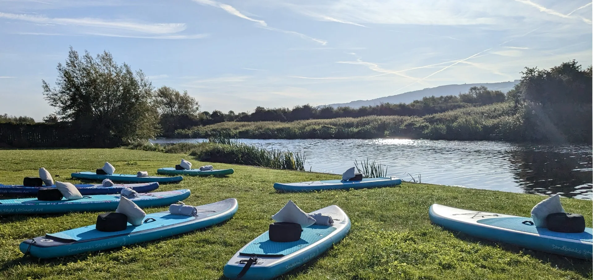 Paddleboards set up with blankets and meditation cushions on the River Avon